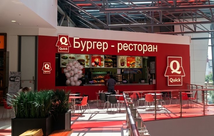 Логотип из нержавейки в интерьере магазина на стене