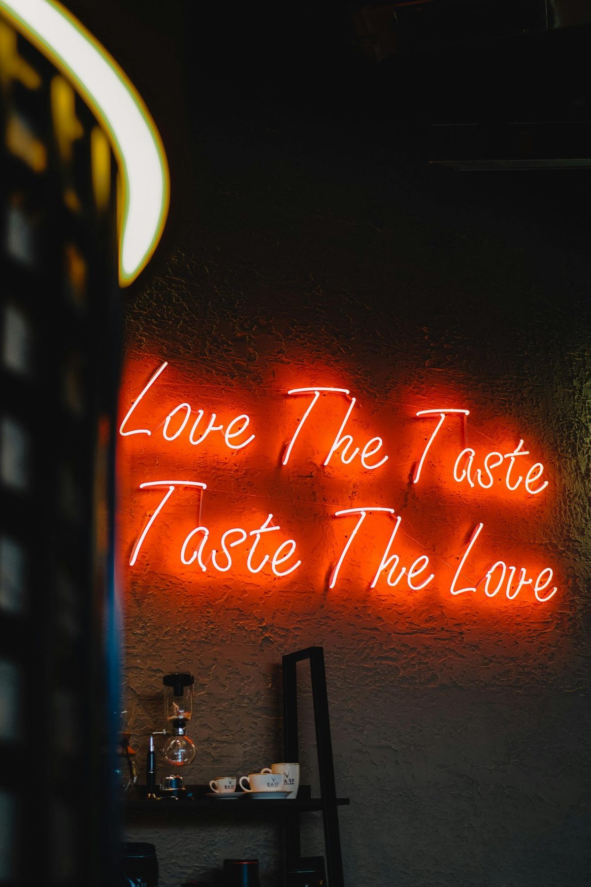 Неоновая надпись Love The Taste Taste The Love в интерьере кафе