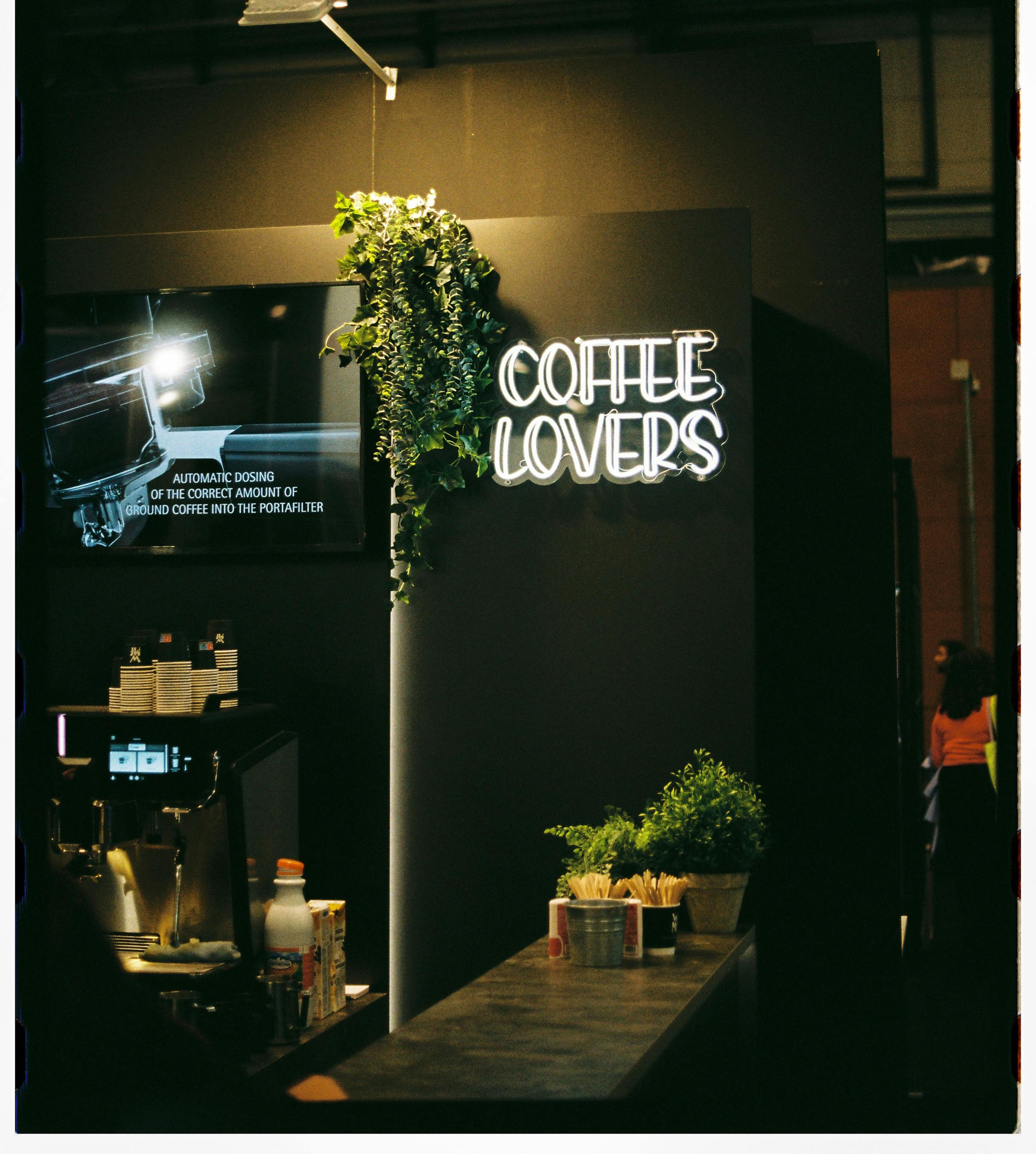 Неоновая надпись Coffee Lovers за барной стойкой кофейни
