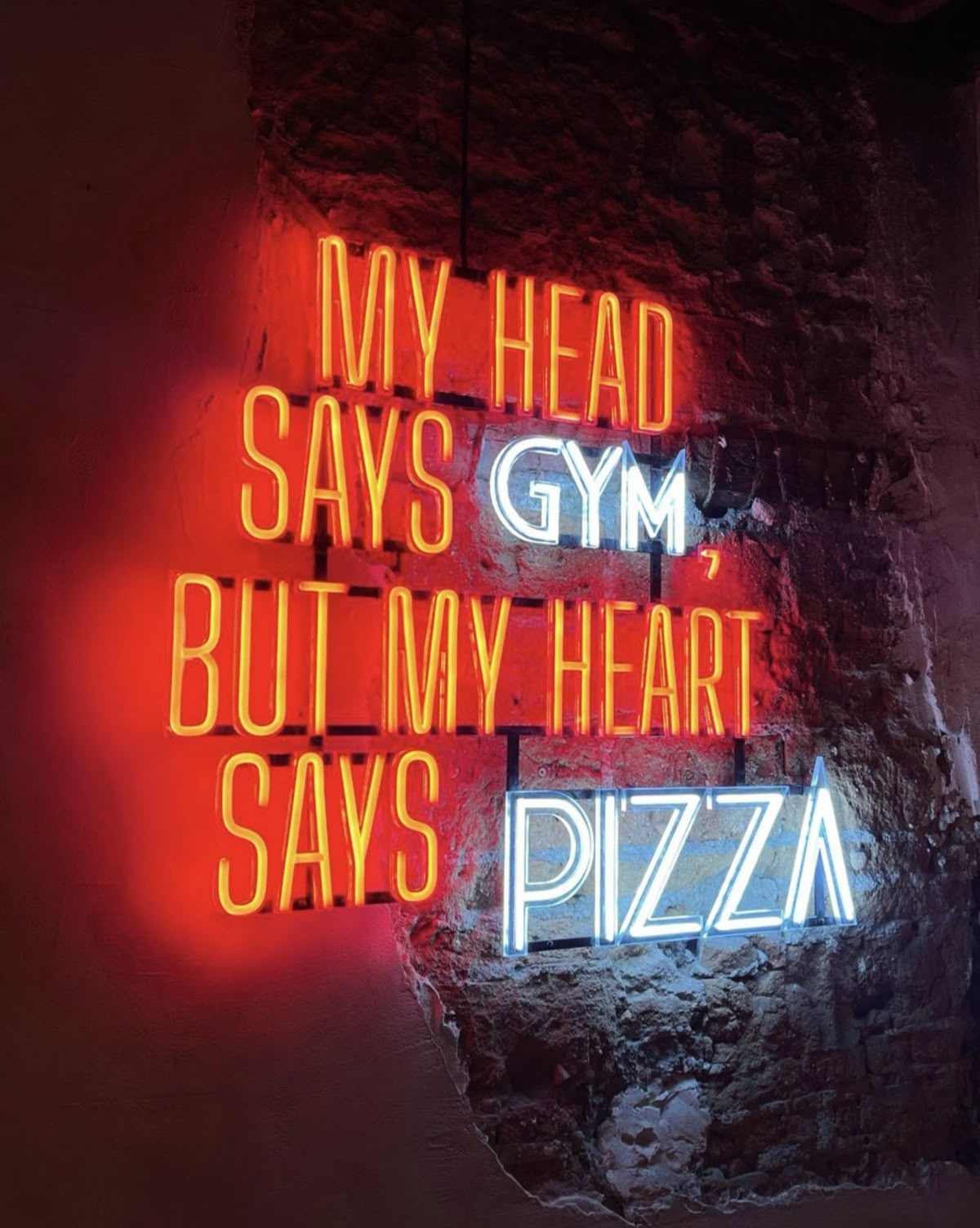 Неоновая надпись My Head Says Gym But My Heart Says Pizza двухцветным неоном в ресторане