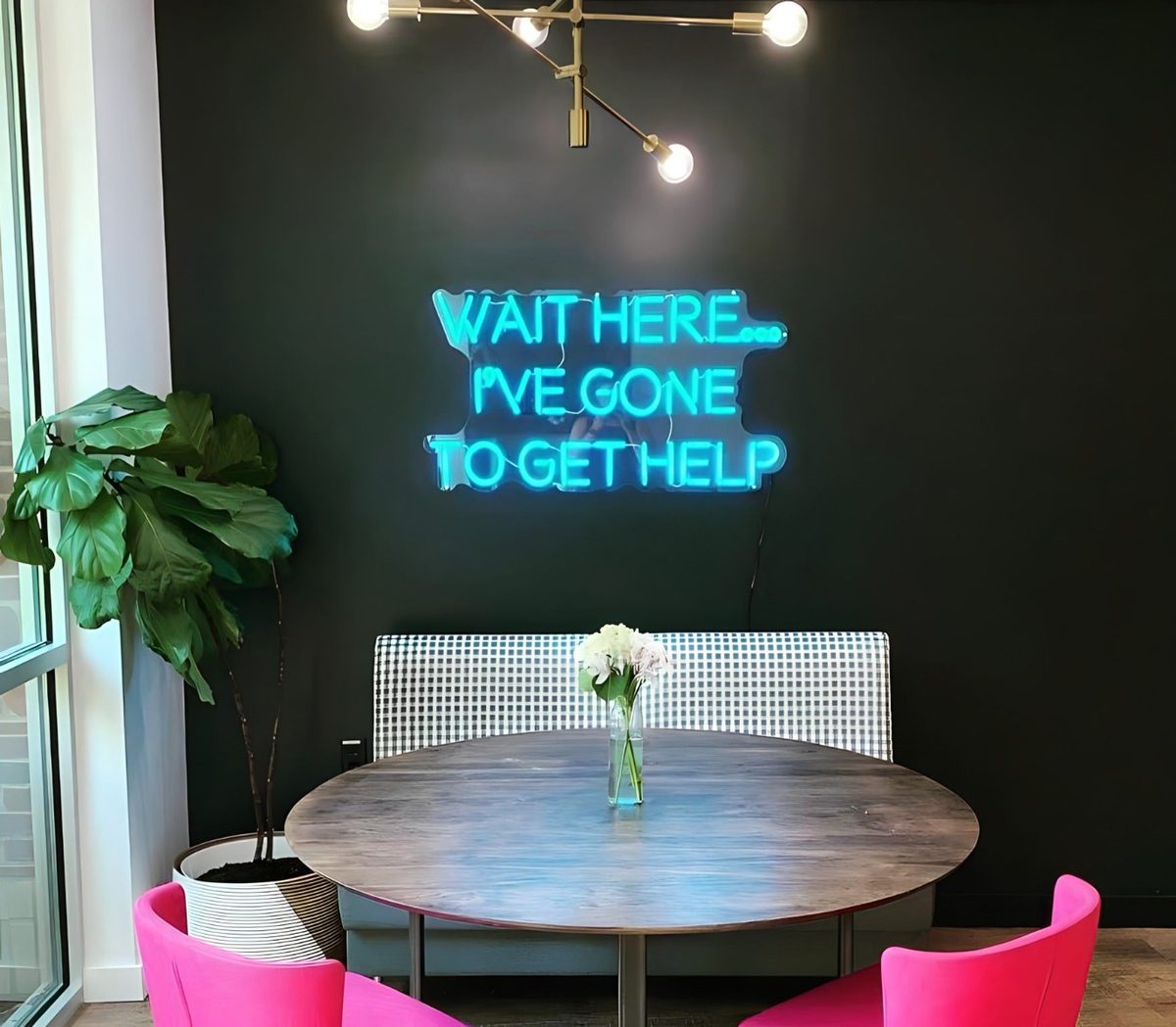 Неоновая надпись Wait Here I've Gone To Get Help в зоне ожидания офиса