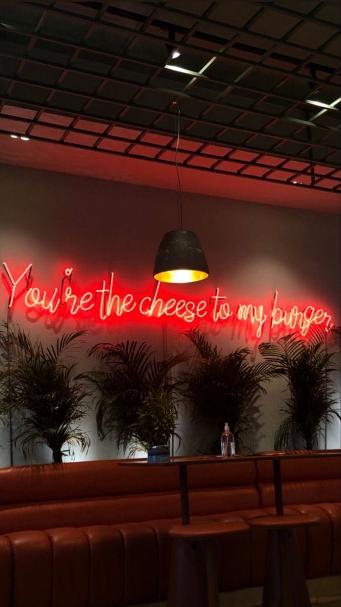 Неоновая надпись You're The Cheese To My Burger красным рукописным неоном в ресторане