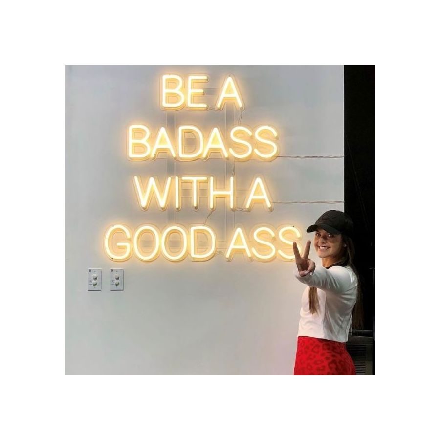Неоновая надпись Be a Badass With a Good Ass тёплым белым неоном в салоне